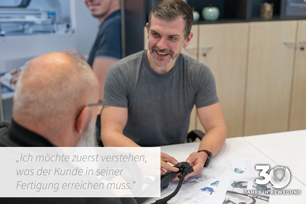 Kundengespräch an einem Tisch mit Musterbauteil und Skizzen